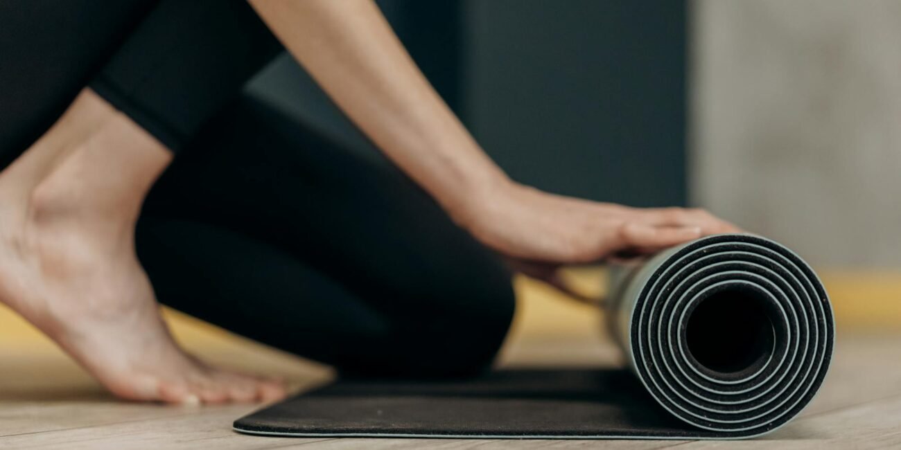 woman rolling a yoga mat