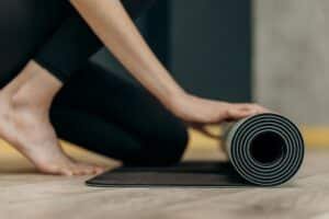 woman rolling a yoga mat